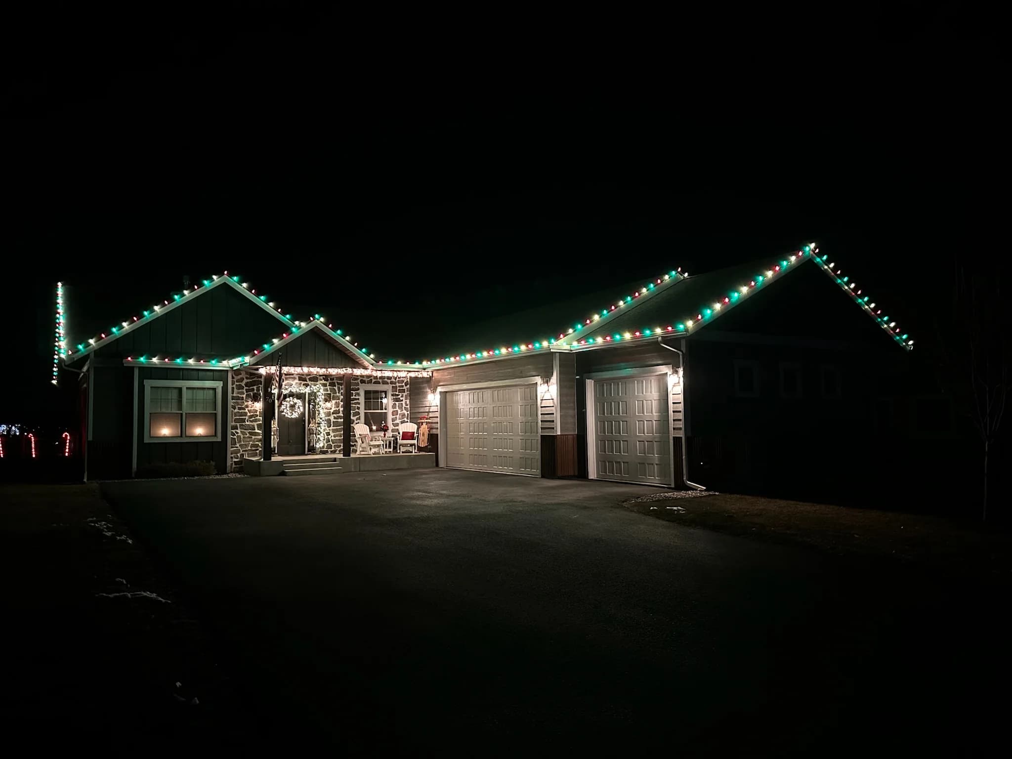 Single-story home with alternating red, green, and warm white roofline lights